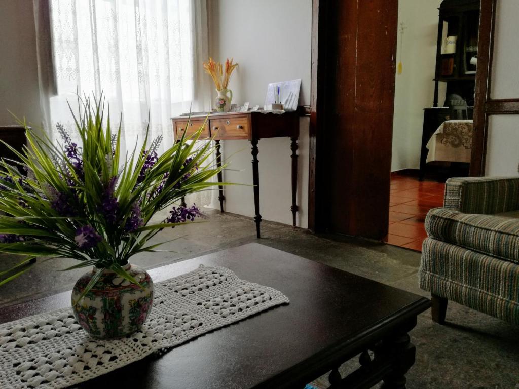 a living room with a vase on a coffee table at Casa do Sr. Alberto in Praia da Vitória