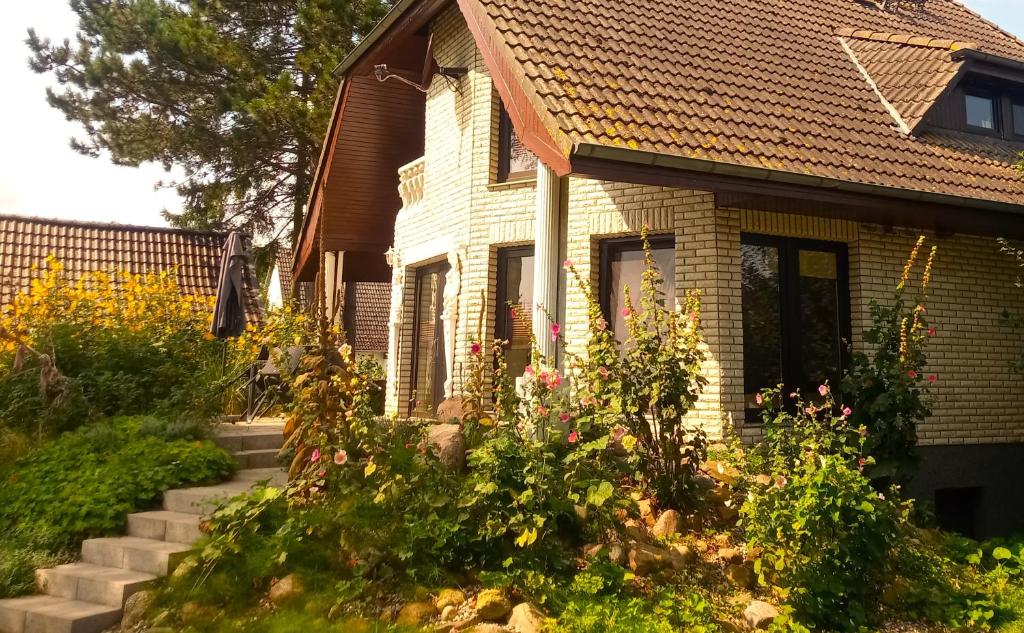 a house with a bunch of flowers in the yard at Fischstübchen Neeberg Fewo 5 – Bootshaus in Krummin