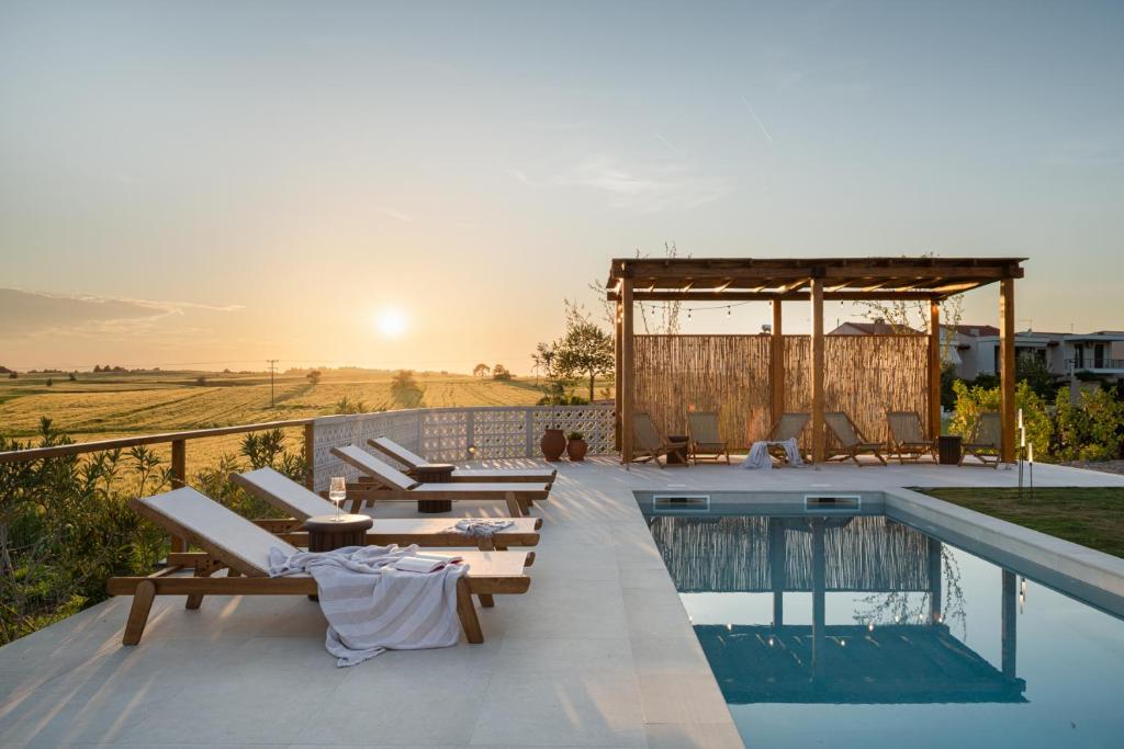 a villa with a swimming pool and a sunset at TERTH - Afytos Experience in Afitos