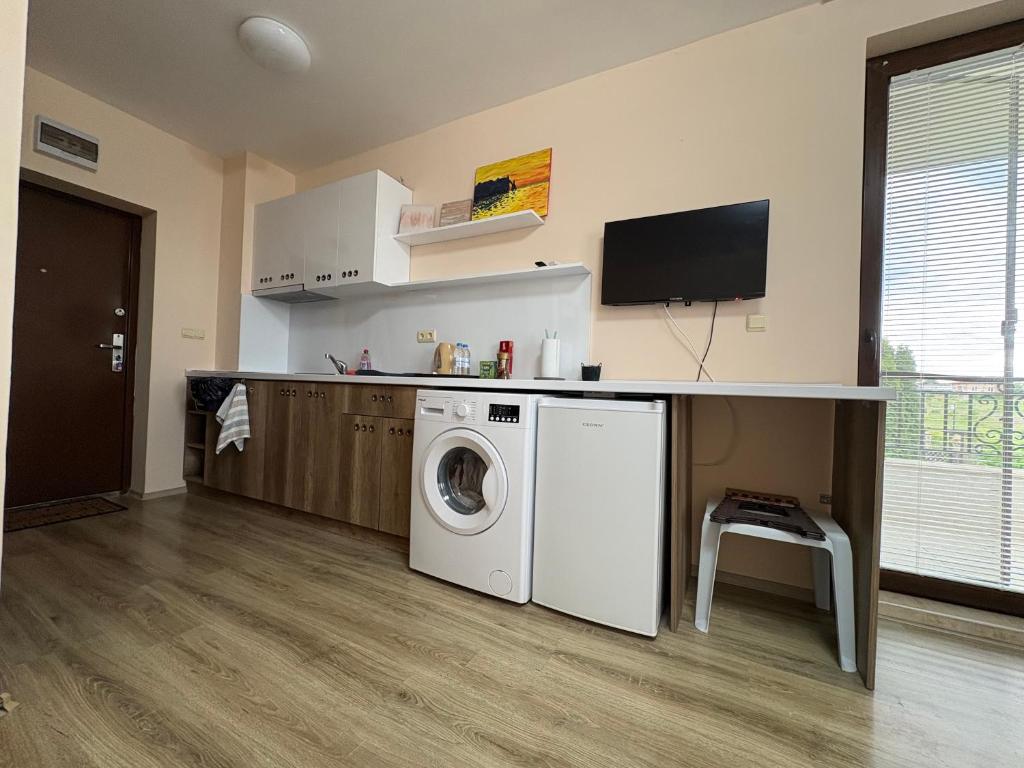 a laundry room with a washing machine and a tv at Равда Аполон 9 in Nesebar
