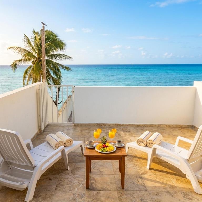 a balcony with chairs and a table and the ocean at MK Hotel Beach in Playa del Carmen