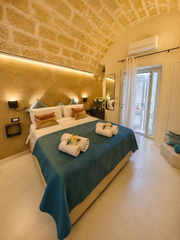 a bedroom with a large bed with towels on it at La Piazzetta Luxury Rooms in Polignano a Mare