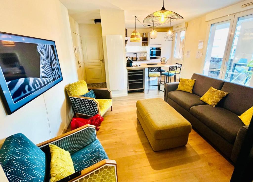 a living room with two couches and a kitchen at L'Écrin du Petit Prince SoCozy in Toulouse