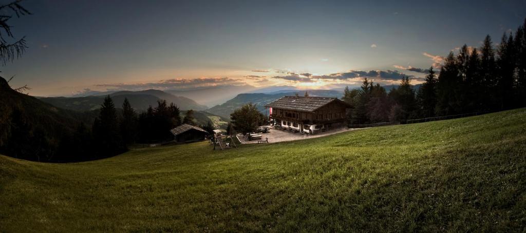 a house on a hill in a green field at HOFERALPL hike-in-mountainhouse in Bagni di Lavina Bianca