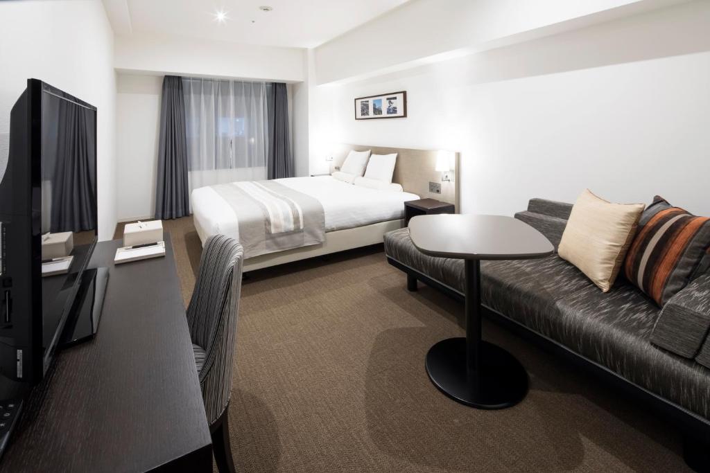 a hotel room with a bed and a couch at HOTEL MYSTAYS PREMIER Omori in Tokyo