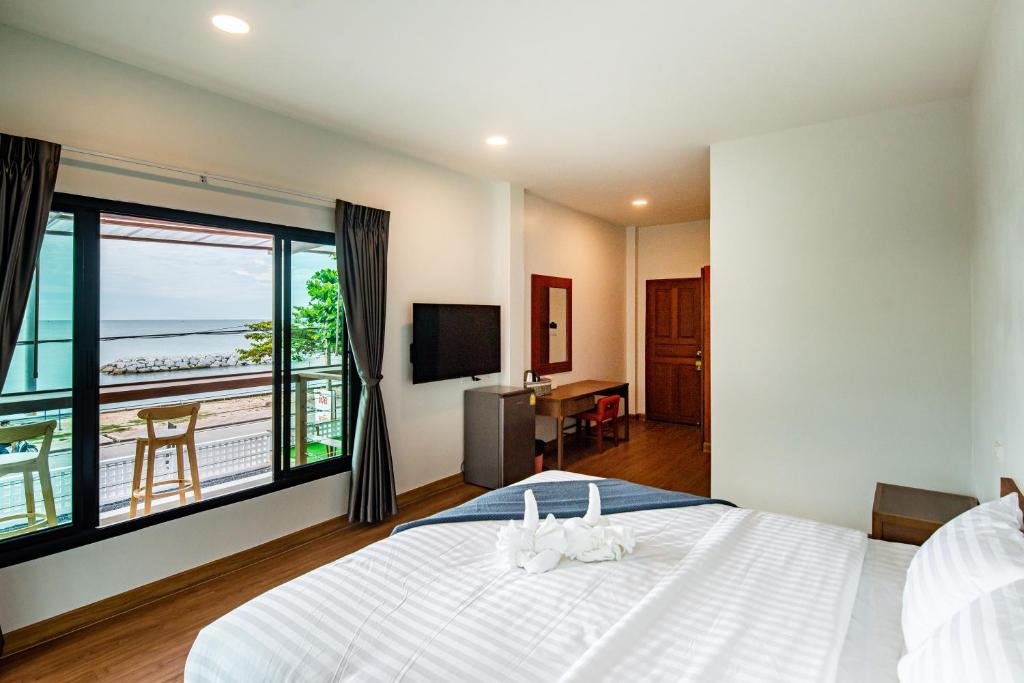 a bedroom with a large bed and a large window at Sinai Rimtalay Hotel in Ban Nong Sanom
