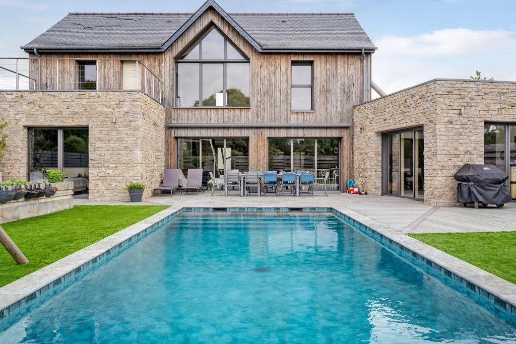 a house with a swimming pool in front of a house at Breizh'ome in Saint-Cast-le-Guildo