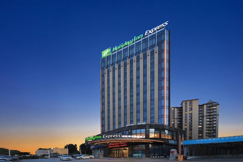 a tall building with a sign on top of it at Holiday Inn Express Linyi West by IHG in Linyi