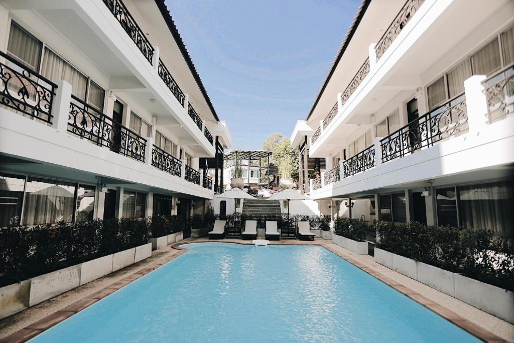 a swimming pool in the middle of two buildings at Fullrich Lanna Suite in Chiang Mai