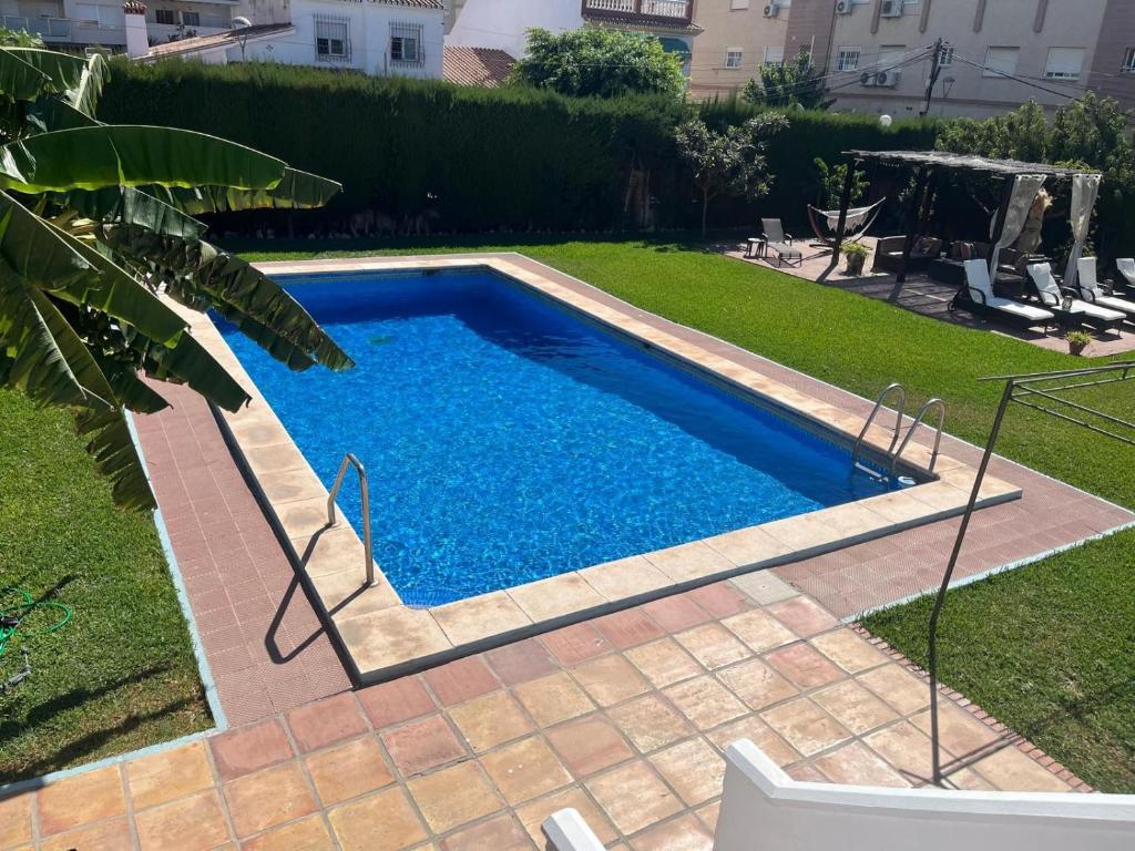 a small swimming pool in a yard with a grass at Villa Dopimar in Rincón de la Victoria