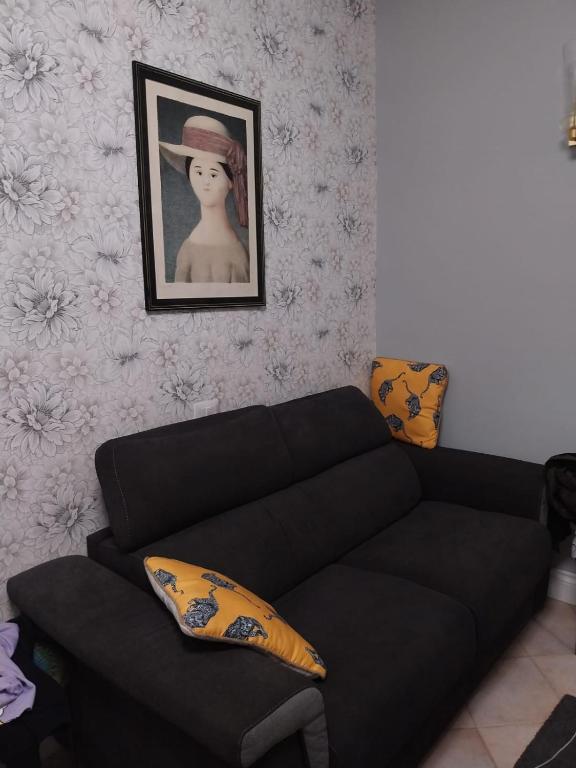 a living room with a black couch and a picture at Casa Patrizia in Velletri