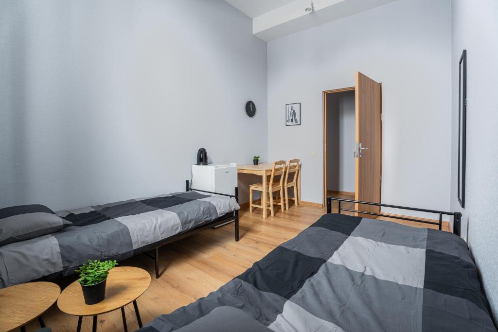 zwei Betten in einem Zimmer mit einem Tisch und einem Esstisch in der Unterkunft Purva3 in Valmiera