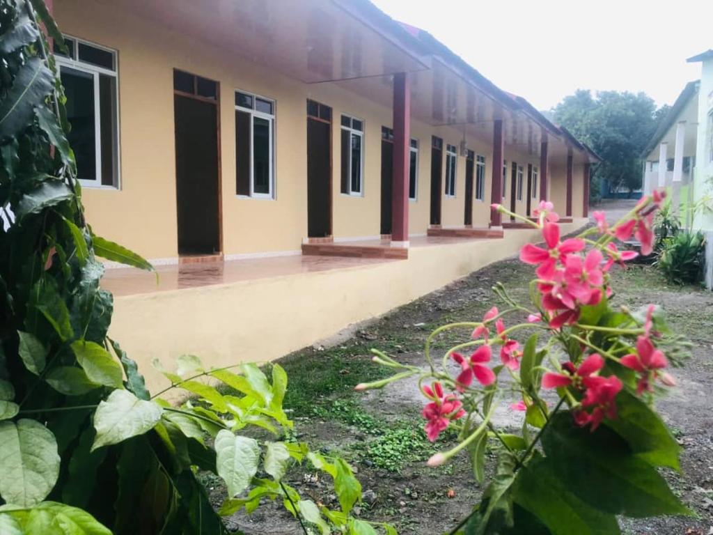 a school building with pink flowers in front of it at Zenaria in Liquica