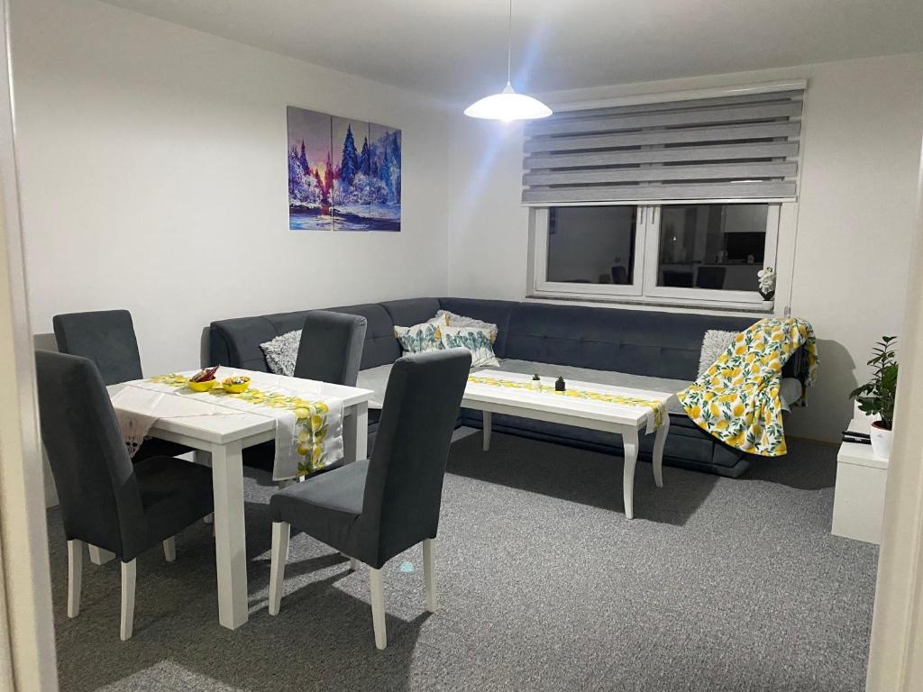 a living room with a couch and a table and chairs at Apartman Nova Pale in Pale