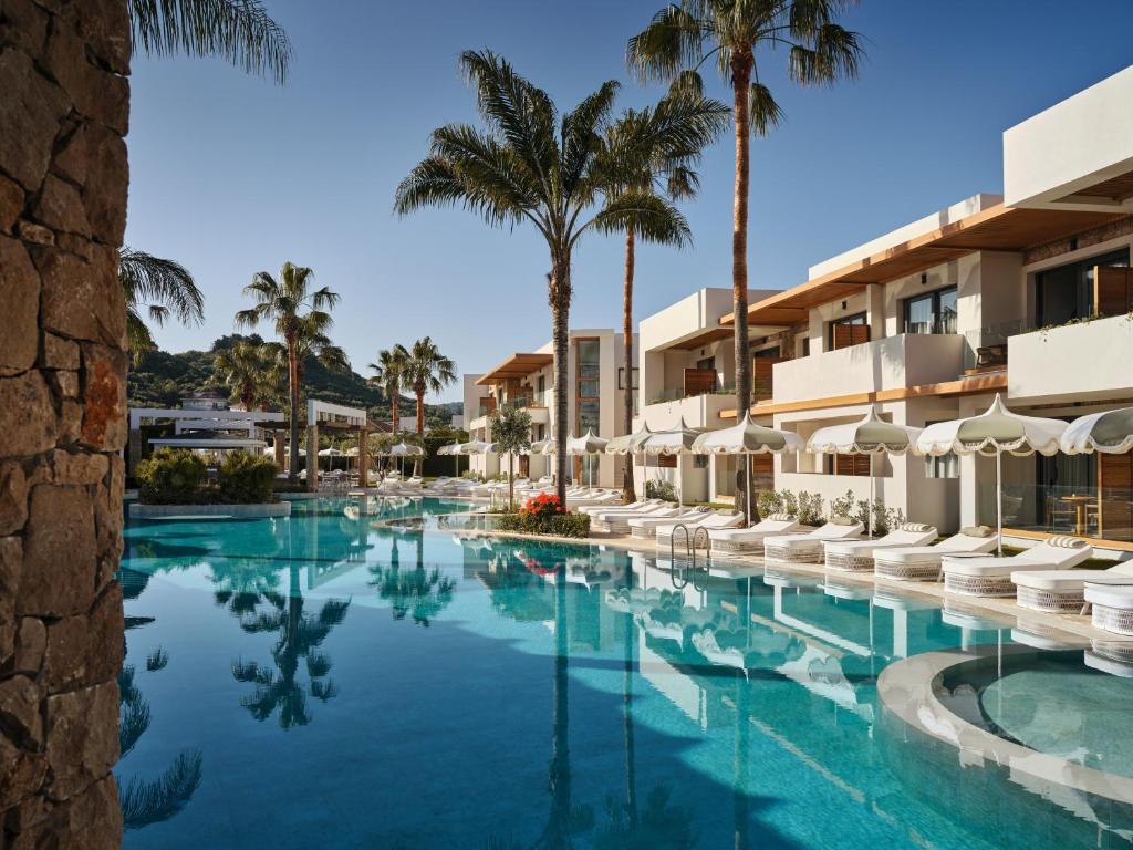 a swimming pool at a resort with palm trees at Lesante Classic - Preferred Hotels & Resorts in Tsilivi
