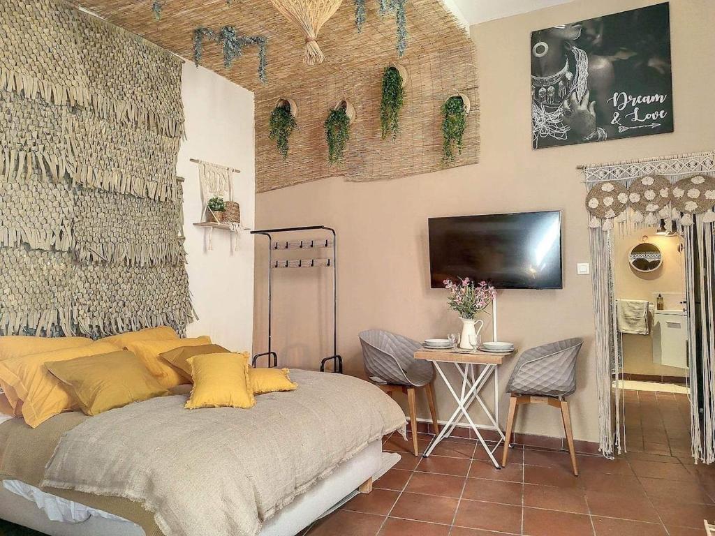 a bedroom with a bed and a table and a tv at Cloître in Arles