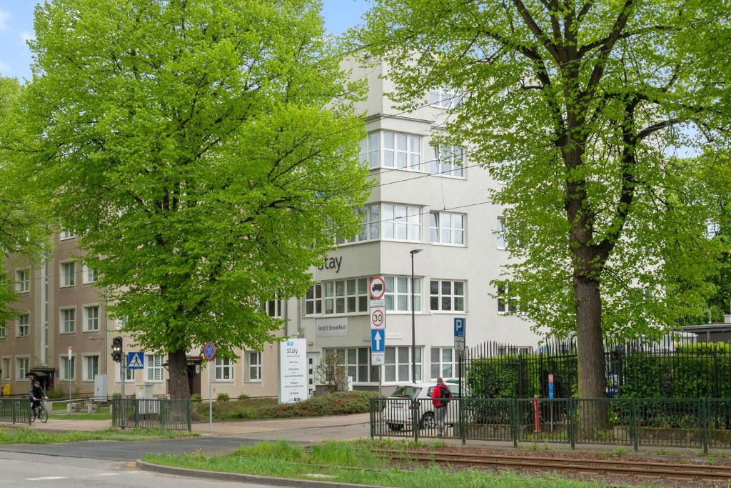a white building with trees in front of it at So Stay Bed & Breakfast - Self Check-in in Gdańsk