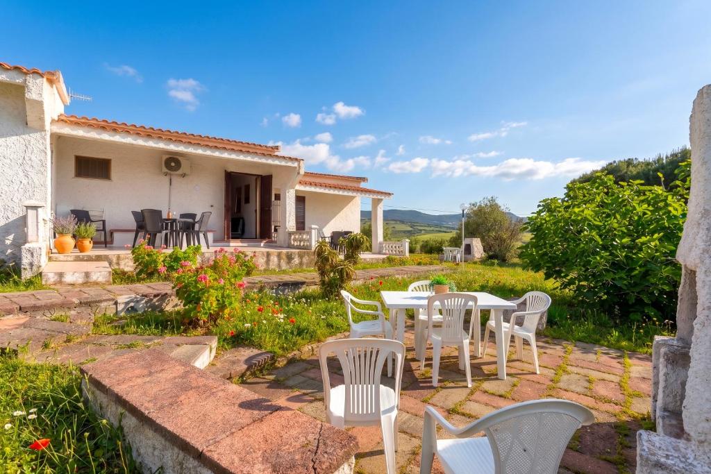 a patio with a table and chairs in front of a house at Villa Rosa Sea View in Valledoria