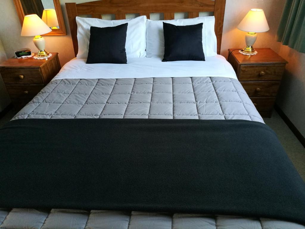 a bedroom with a large bed with two night stands at Hacienda Motel in Invercargill