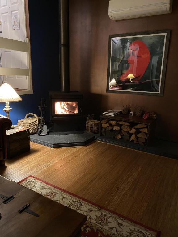 a living room with a wood burning stove in a room at The Red Cottage in Wentworth Falls