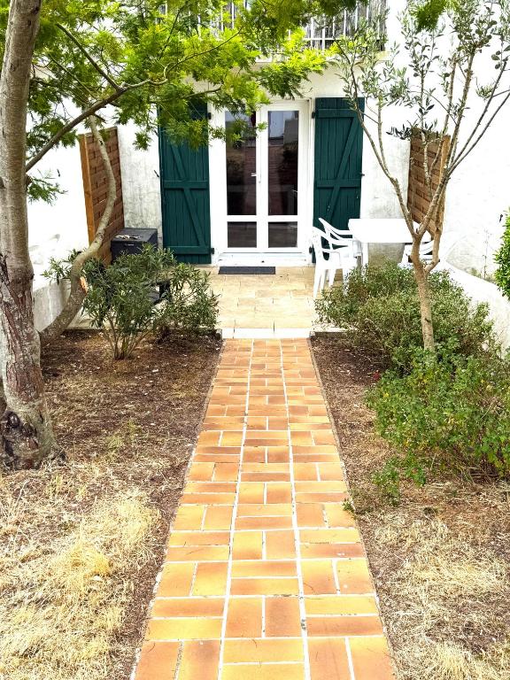 a brick walkway in front of a house at Studio cosy les Sables d'Or in La Guérinière
