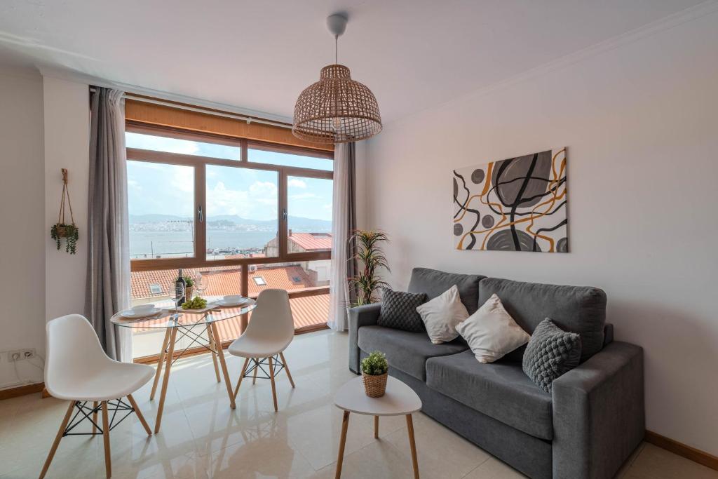 a living room with a couch and a table and chairs at El Balcon de Moaña in Moaña
