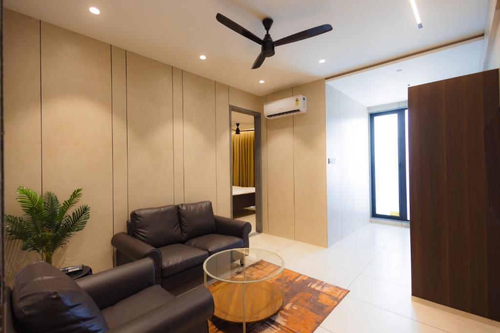 a living room with a couch and a ceiling fan at Nirrtul Crystal 1BHK Apartment Cozy & Quite in Surat