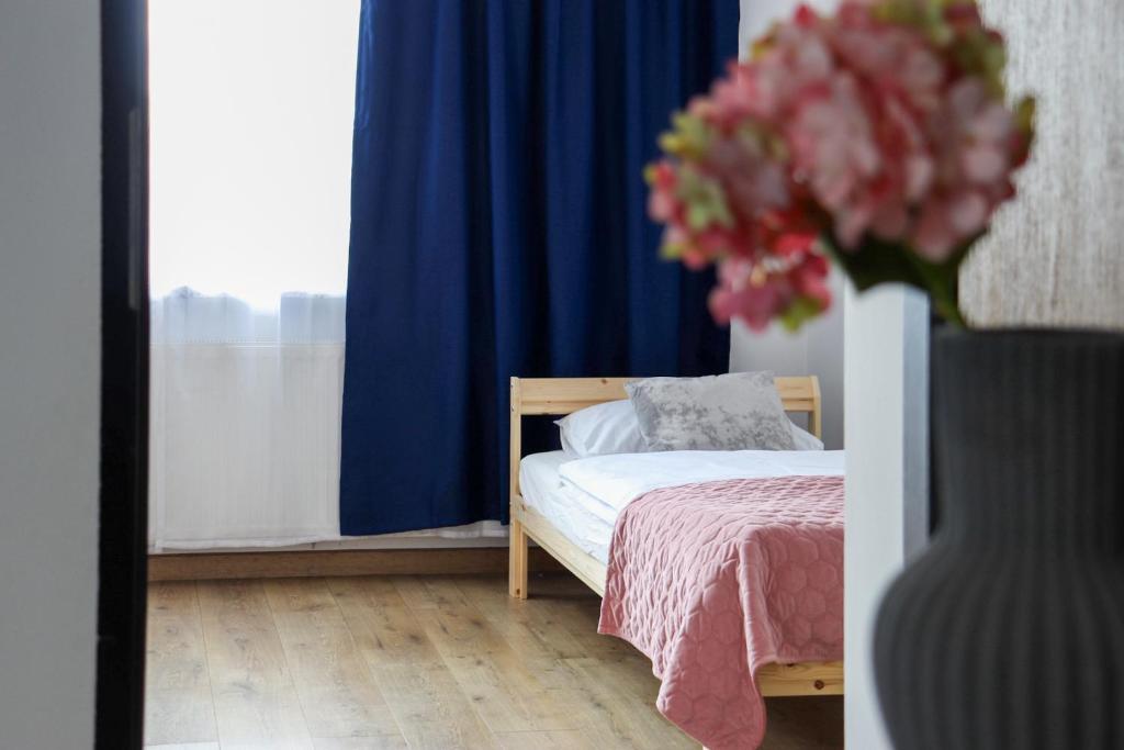 a bedroom with a bed and a vase of flowers at Apartamenty Piotrowice in Piotrowice