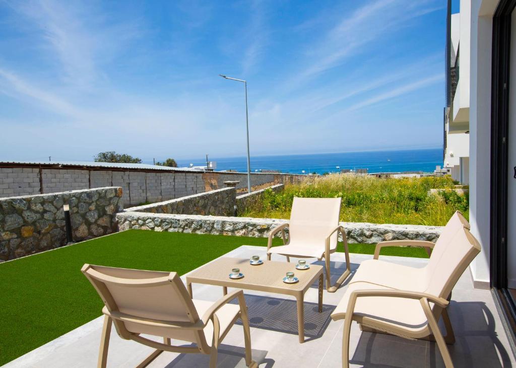 a patio with chairs and a table and a view of the ocean at Aqualina D5-1 by HolidayKeys in Kyrenia