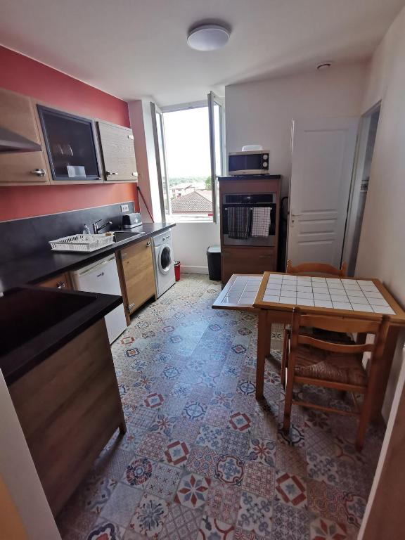 a kitchen with a table in the middle of it at Studio au coeur pays basque in Ustaritz