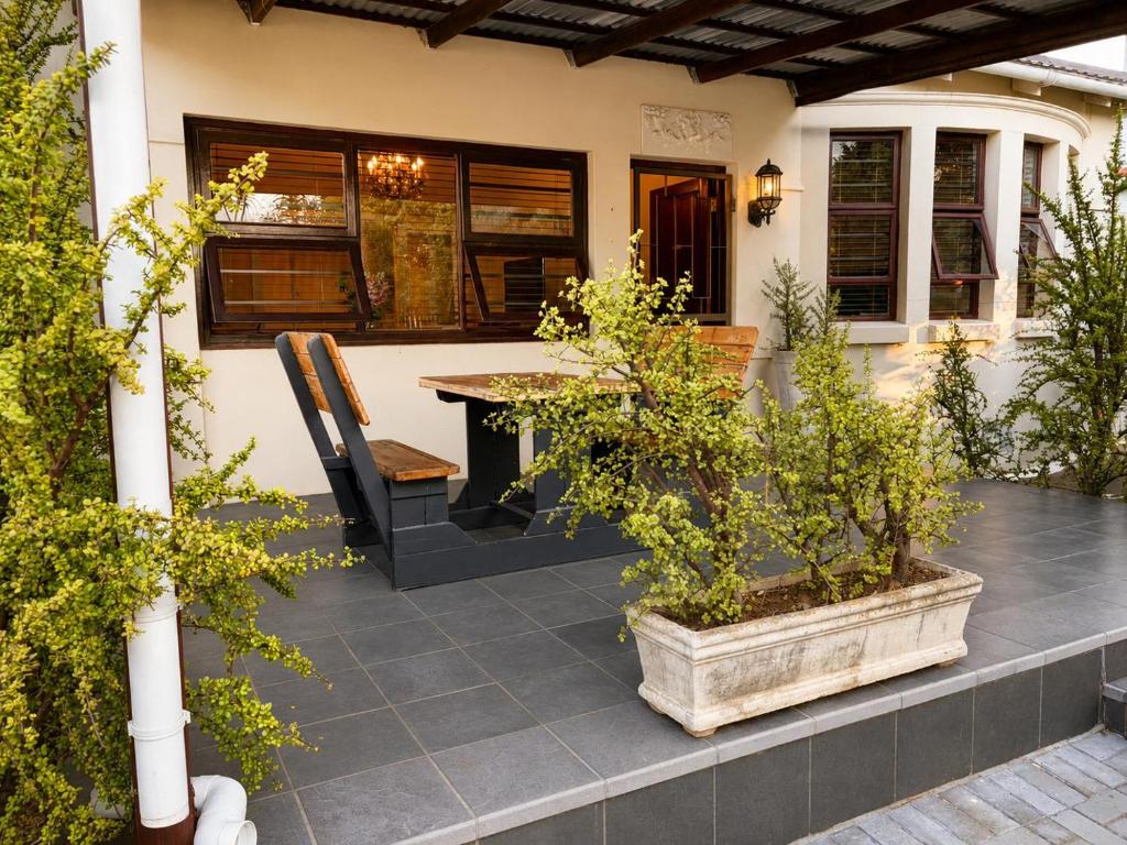 a patio with a table and chairs and plants at Serenity Stay- Walmer in Gqeberha