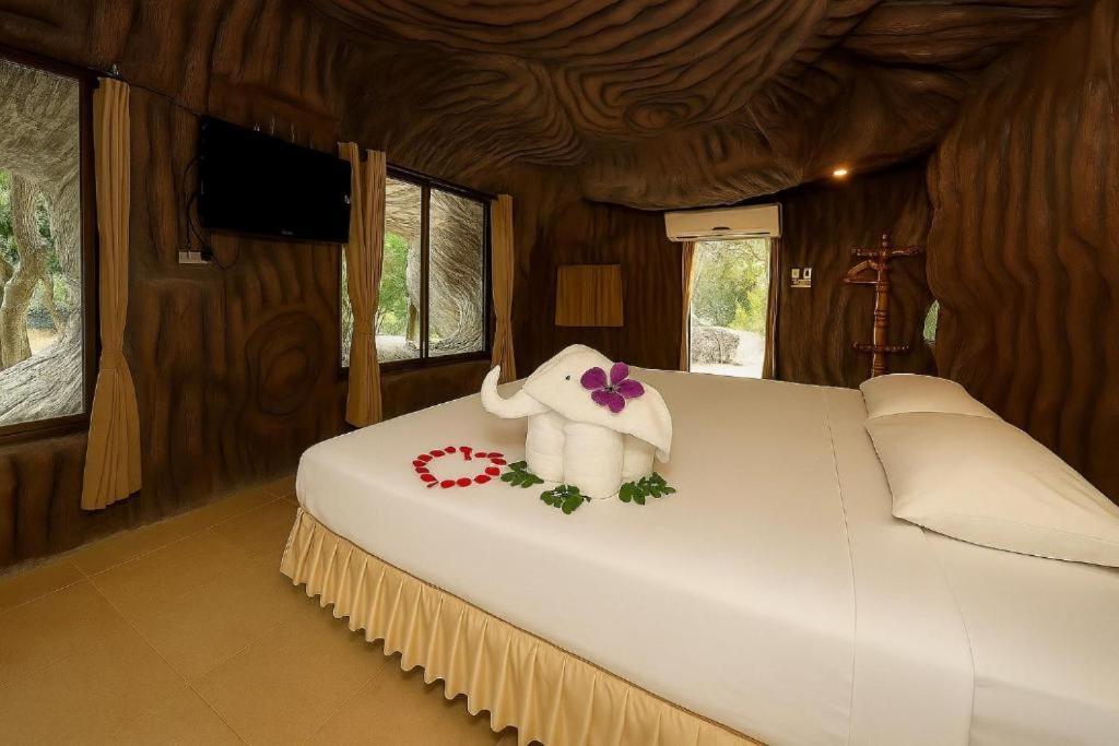 a bedroom with a large white bed with flowers on it at 19 Degrees Resort in Sai Yok