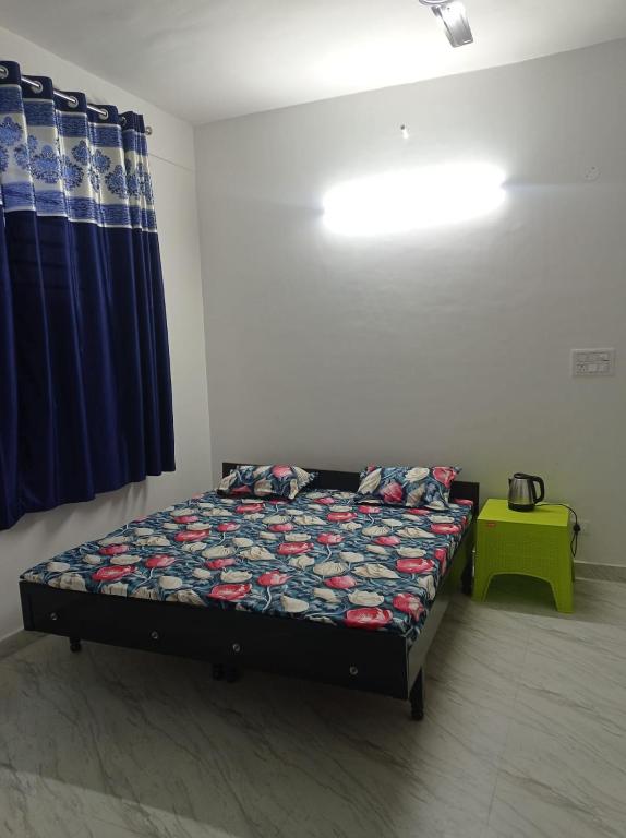 ein Bett in einem Zimmer mit einem blauen Vorhang in der Unterkunft Rana Complex in Nādaun