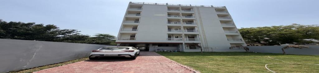 a white car parked in front of a building at Sky Homestay in Noida
