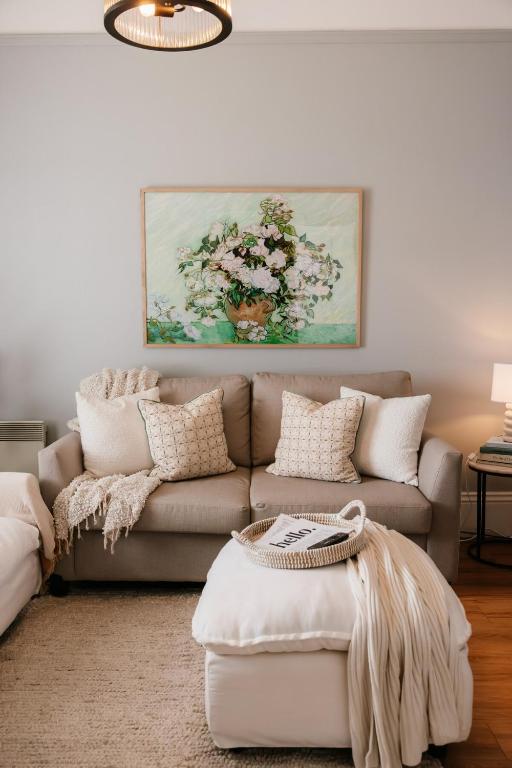 a living room with a couch and a painting at Charm on Forster in Invermay
