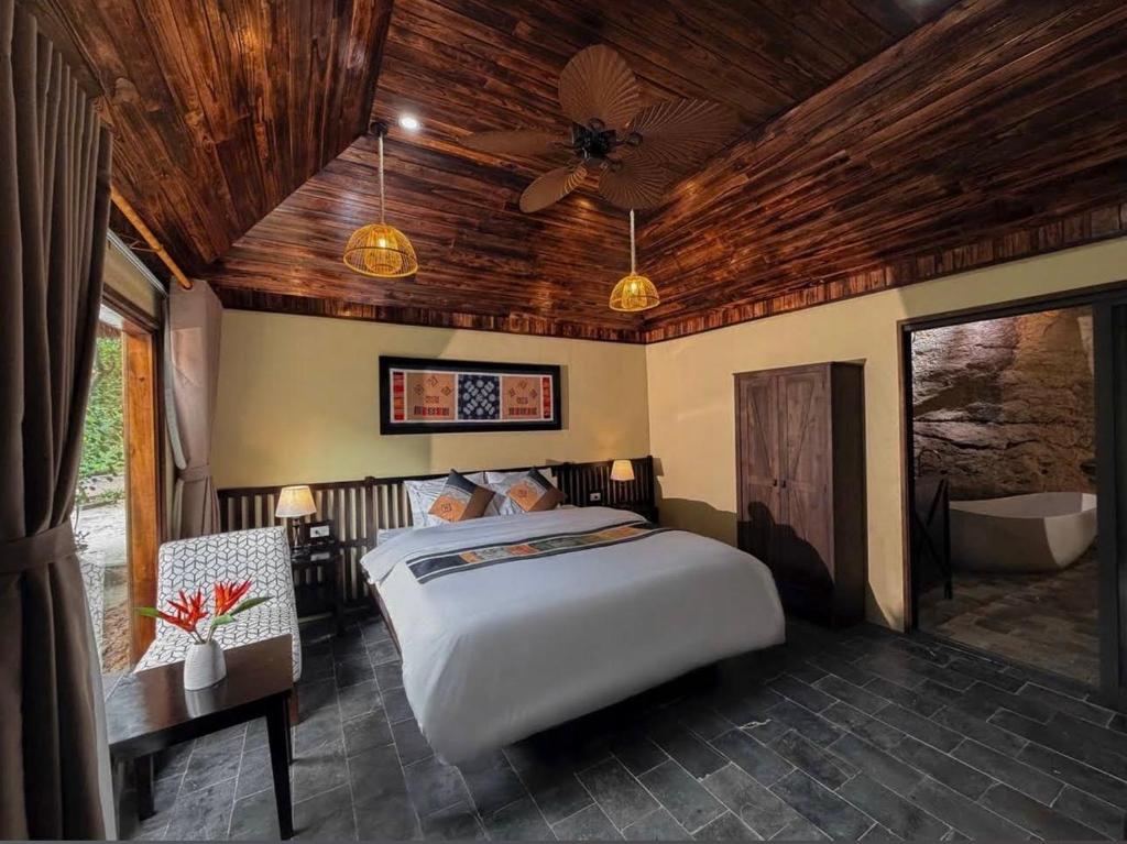 a bedroom with a large bed and a bathroom at Tràng An Valley Garden in Ninh Binh