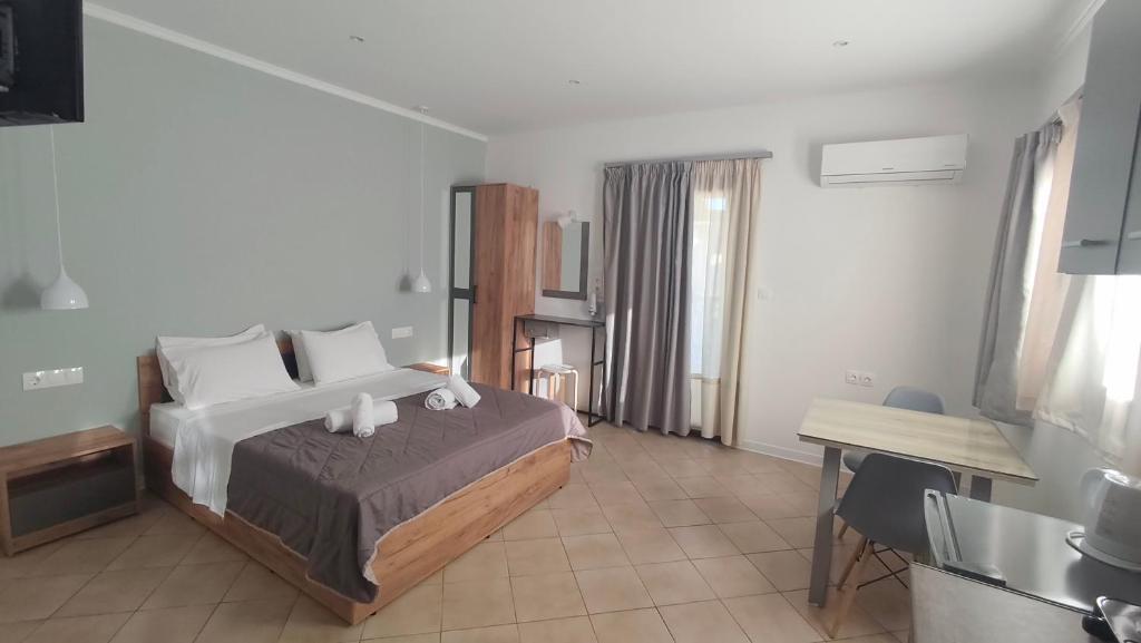 a bedroom with a bed and a table and a desk at Smaragda Hotel in Marathokampos