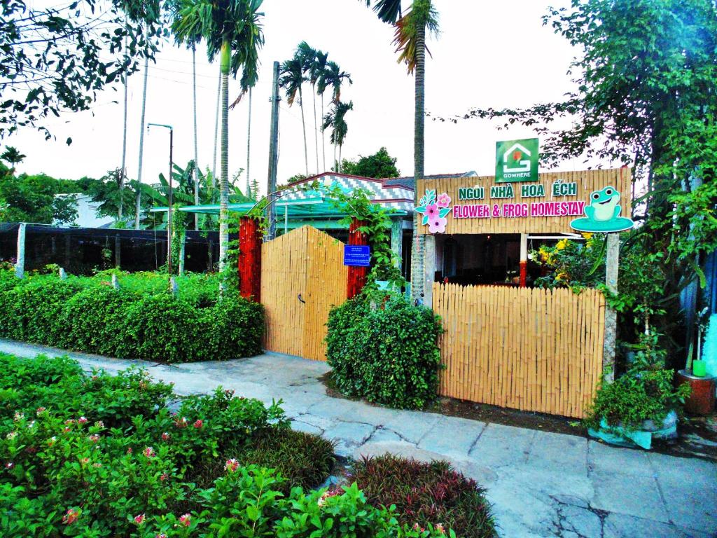 a restaurant with a sign in front of a fence at Flower & Frog Homestay in Sa Ðéc