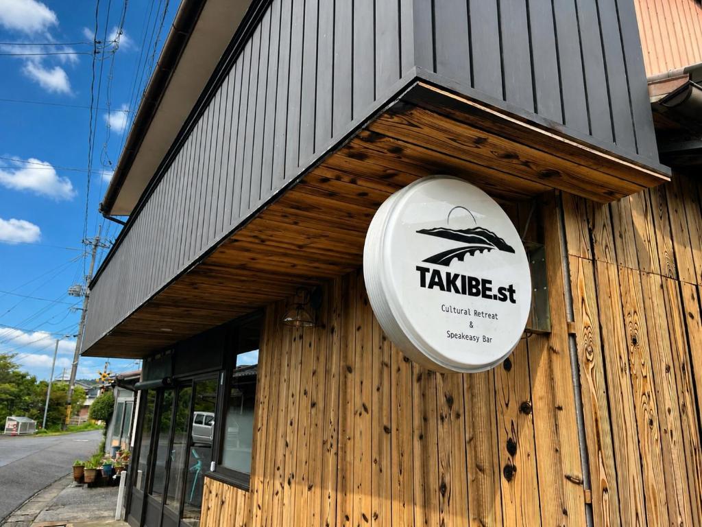 a sign on the side of a wooden building at TAKIBEst Bnb&Bar in Takibe
