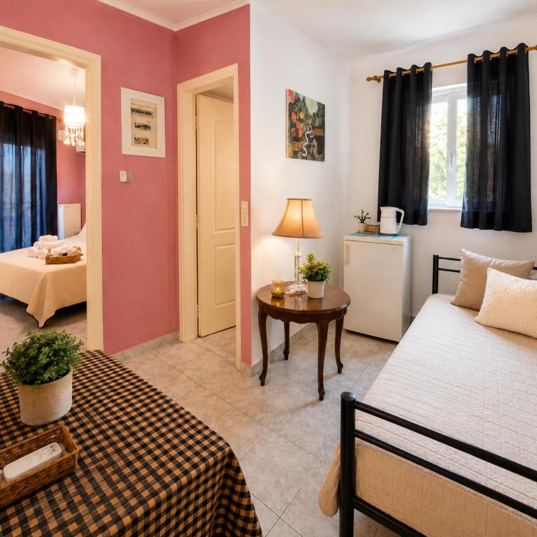 a bedroom with two beds and a table in a room at Sunset Apartments in Missolonghi