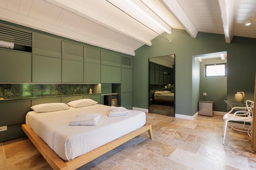 a bedroom with a large white bed and green walls at Aritis 3 in Corfu