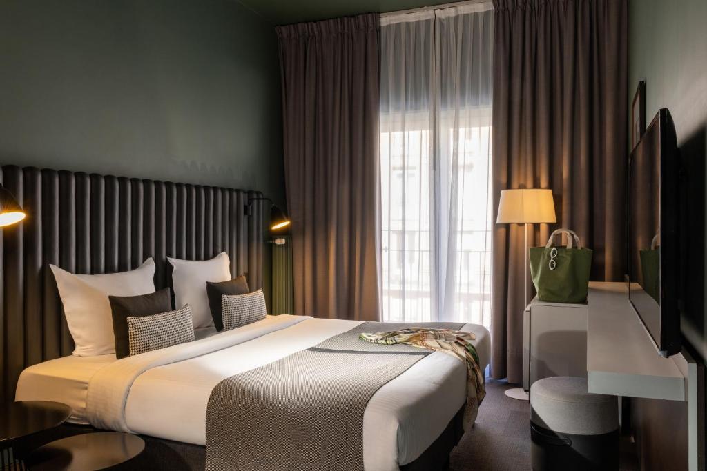 a hotel room with a large bed and a window at Hôtel Diana Dauphine in Strasbourg