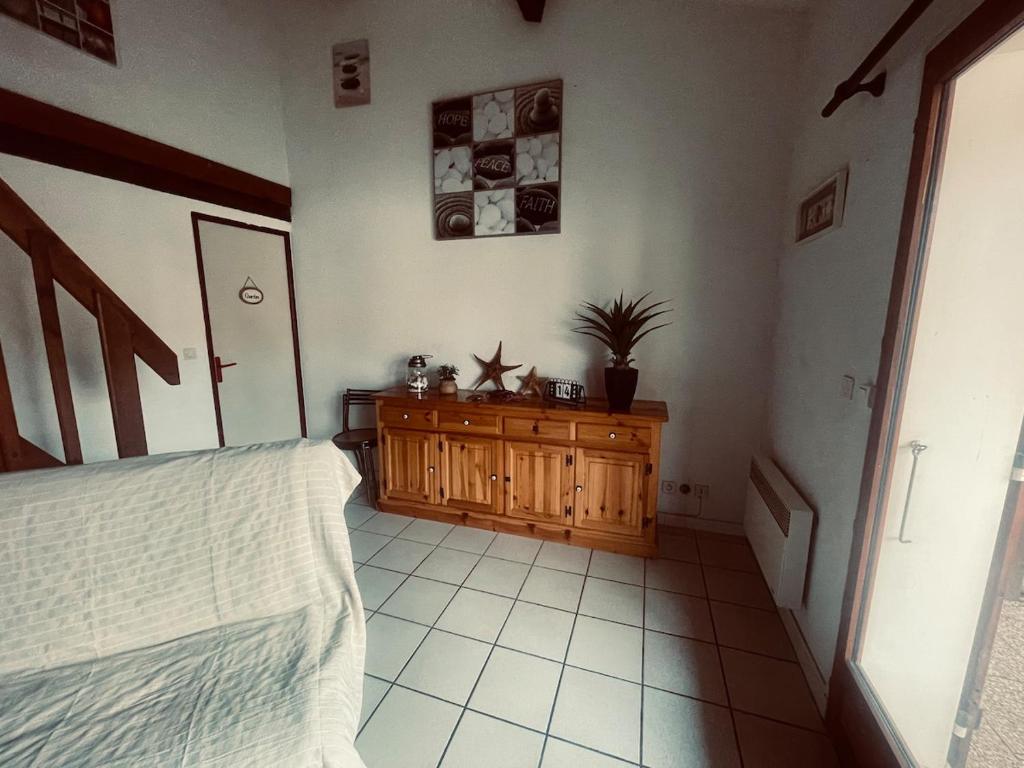 a bedroom with a bed and a wooden dresser at L'Ancre Marine in Valras-Plage