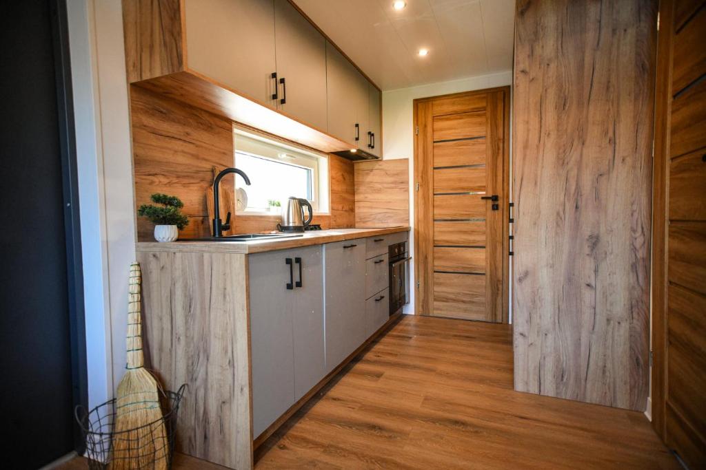 a kitchen with wooden walls and a sink and a counter at Domek Klara in Wałbrzych