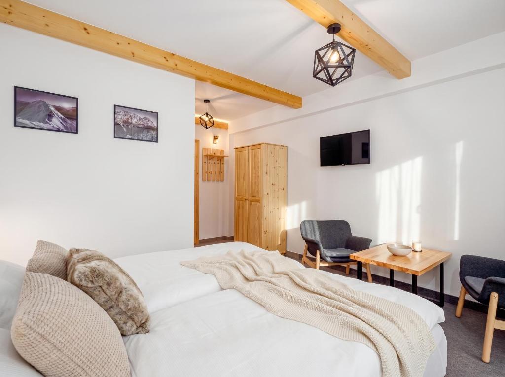a bedroom with a bed and a table and chairs at Golden Apartments - Villa Taternik - Studio with balcony in Zakopane