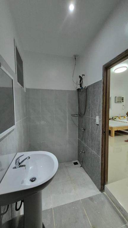 a bathroom with a white sink and a shower at Beachfront White House for 10pax in Caba