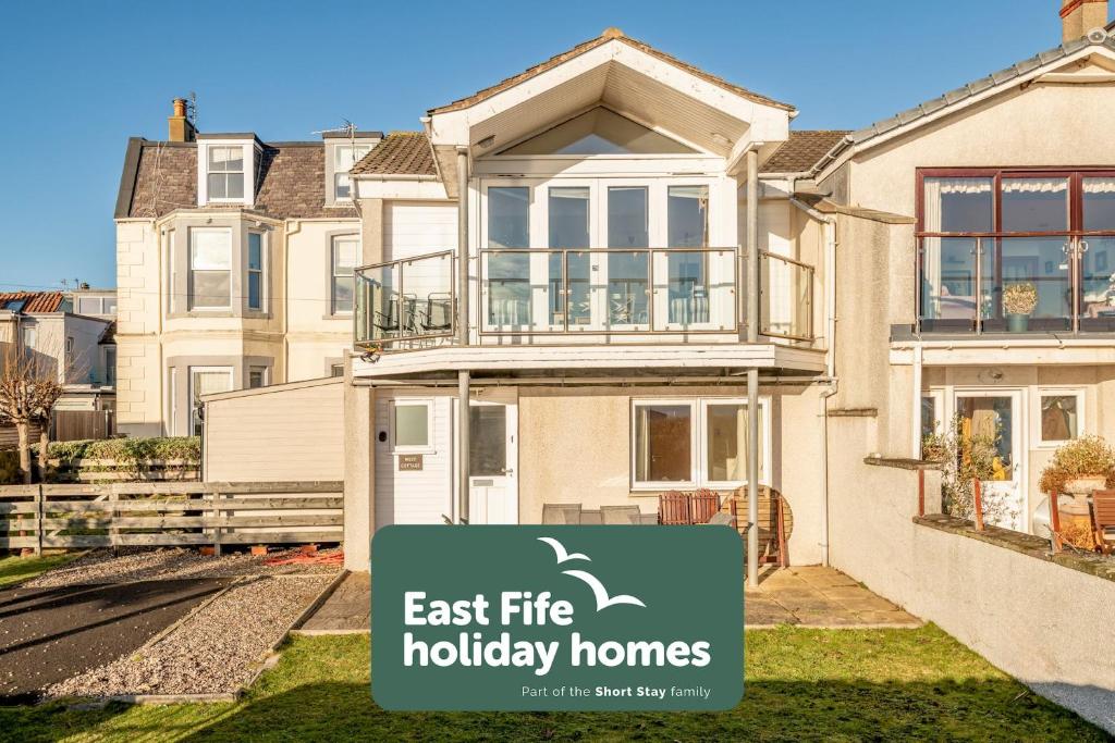 a house with a sign that says east fire holiday homes at West Cottage - Elie in Earlsferry