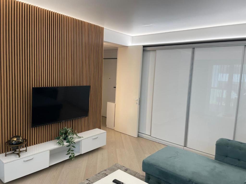 a living room with a flat screen tv on a wall at Suite Luxury Pipera and Spa in Bucharest