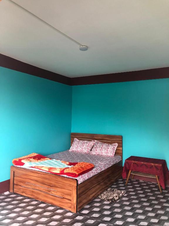 a bedroom with a bed and a blue wall at Fable homestay in Pedong