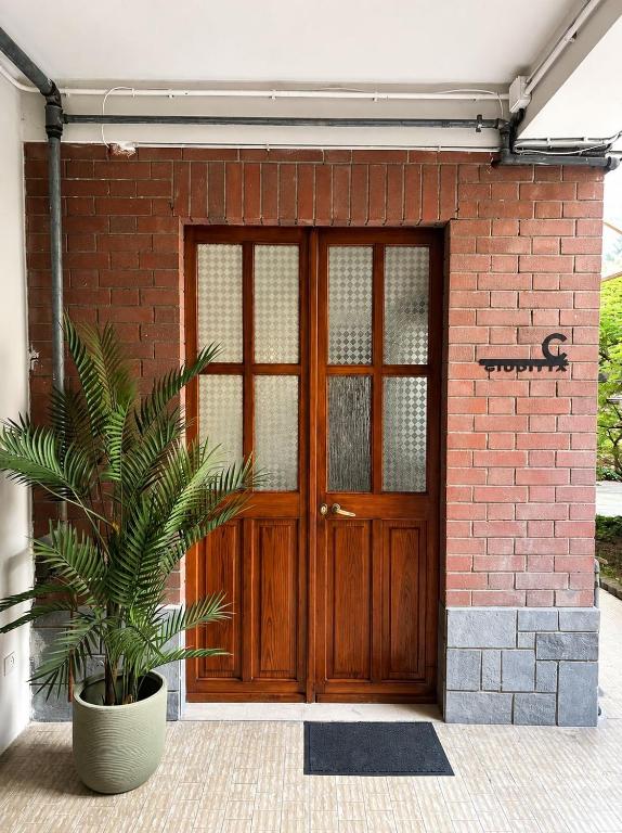 a wooden door with a plant in front of a brick building at Giuditta Room C in Ciriè